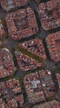 Aerial birds eye view of rectangular buildings architecture and traffic in Barcelona. Drone hyper lapse shot over Eixample residential urban streets grid of Catalonia, Spain. Vertical mobile screen.