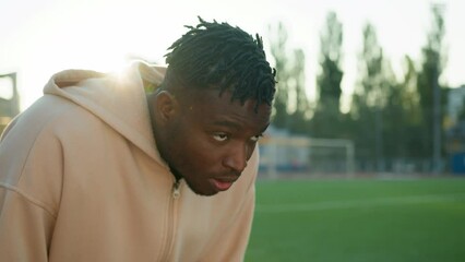 Tired exhausted African american man male sportsman athlete runner rest after hard workout outdoors sweaty guy footballer stop running pause recreation physical exercise heavy breathing training sport