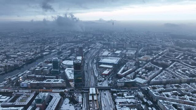 City of Berlin, Germany from above. Aerial winter cityscape view showing architectural landmarks Oberbaum Bridge, TV Tower and Berlin Cathedral in winter. A dark, dramatic urban landscape in grey-blue