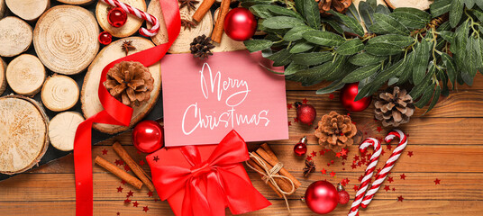 Beautiful Christmas composition with greeting card, gift box and decor on wooden background