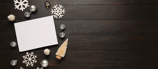 Beautiful Christmas composition with blank card and decor on dark wooden background with space for text