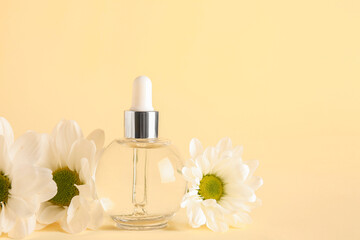 Bottle of essential oil with chamomile flowers on color background