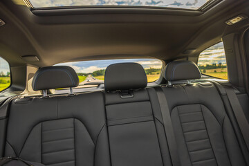 Beautiful rear view interior with leather seats and panoramic sunroof of new black electric car...