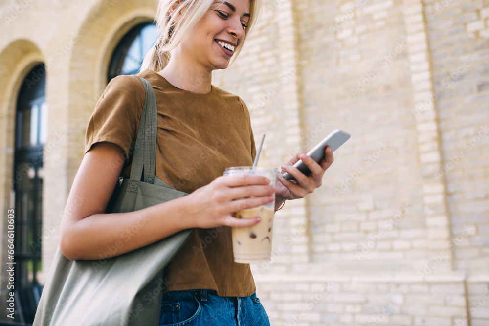 Aufkleber joyful travel blogger with ice coffee enjoying mobile chatting and messaging via cell technology, ha