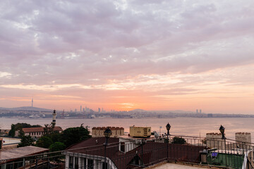 Beautiful landscape with sunrise over the city roofs, the bay and the city in the background. Dawn...