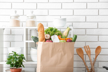 Paper bag with different products and utensils in kitchen