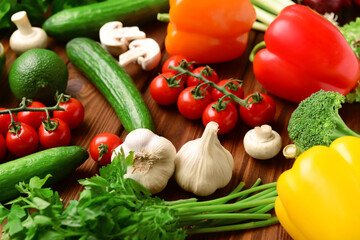 Fresh vegetables, greenery and mushrooms on wooden background