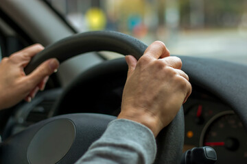 Woman hands holding steering wheel
