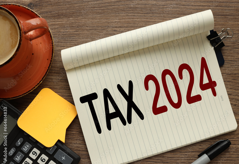 Poster 2024 taxes new year symbol. top view on a wooden table. mug and notepad with text near calculator. b