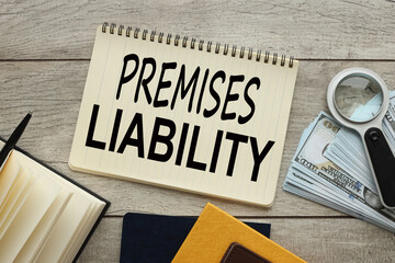Premises liability work desk with notepad. bills of money and a magnifying glass. words