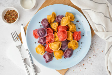 Plate of boiled colorful dumplings with peppercorn on white background