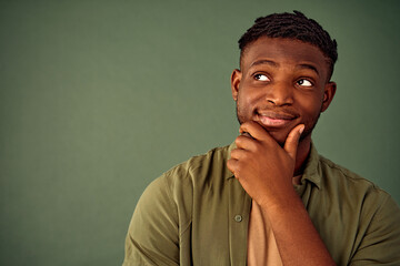 Lost in thoughts. Close up portrait of african american man standing over green background with...