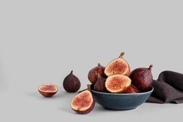 Bowl with fresh ripe figs on white background