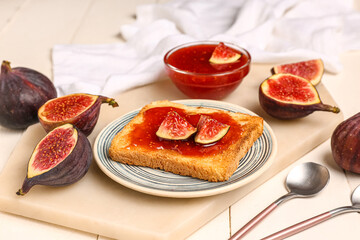 Plate of toast with sweet fig jam on white wooden background
