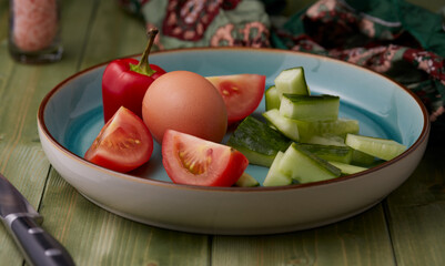 Mixed vegetables and a hard boiled egg on a plate ready for eating.