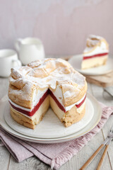 Polish Carpathian cake Karpatka. Cream puff cake with strawberries. Wooden table and pink background.