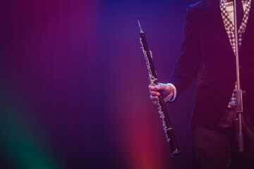 close-up photo of a musician's hand holding a black wooden clarinet music playing concept
