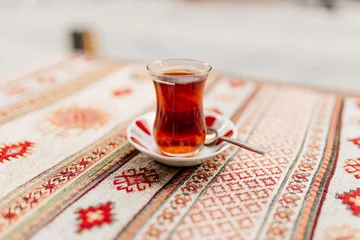 Foto op Plexiglas Turkish black tea in national dishes stands on the table with a napkin with Turkish patterns. Dessert close-up. Breakfast in a cafe. Turkish ornament © Liudmila