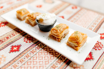 Turkish sweets on Turkish white and red napkins. Dessert close-up. Delicious pastries on the table. Baklava on a white plate