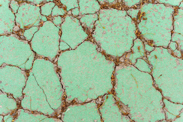 Fototapeta premium Texture of old cracked green concrete on the street.