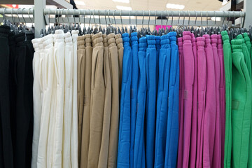 Beautiful women's trousers hanging on hangers, sold in a fashion store.