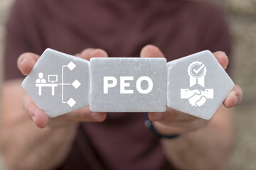 Man holding white foam blocks sees abbreviation: PEO. Concept of PEO Professional Employer...