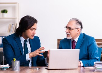 Obraz premium Young and old employees working together in the office