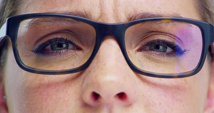 Glasses, vision and portrait closeup of a woman in a studio with green eyes with her pupils and cosmetic makeup. Macro zoom of confused female person with optical eyesight spectacles for prescription