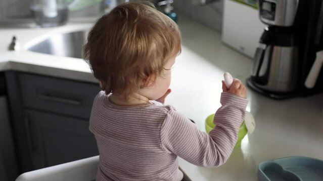 Toddler playing in the kitchen with household objects