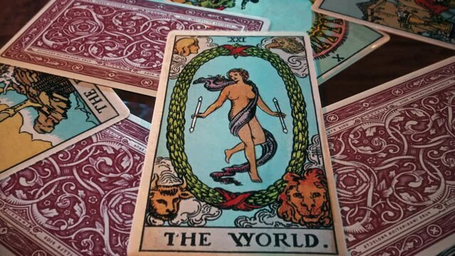 Paris, France - January 14, 2021. Using the mystery divination spell to read magical The World Tarot Card. Casting the mystery divination spell to predict future. Mystery divination spell ritual.