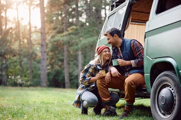 Foto op Plexiglas Happy couple enjoys in cup of warm tea while camping in nature in autumn. © Drazen