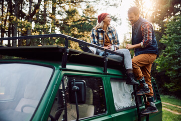Fototapeta premium Happy woman and her boyfriend with their camper trailer spending day in nature.