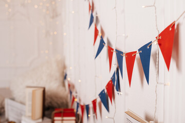 String bunting in red, blue, and white colors hanging in a cozy room.