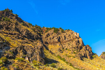 Rock walls with building ruins next to the railroad tracks in Royal Gorge in Colorado