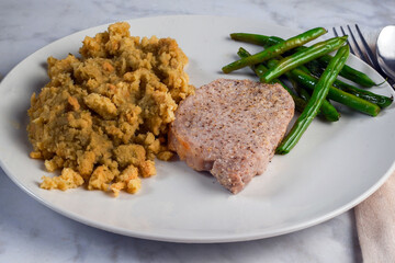 porkchop served with stuffing and sauteed green beans