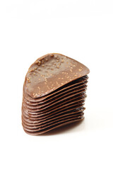 Stack of thin chocolate covered chips isolated on white background