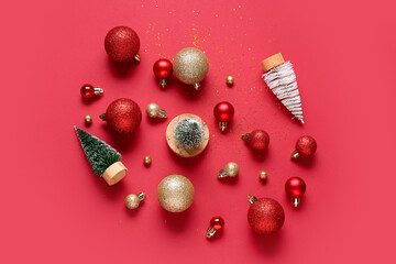 Composition with Christmas balls and fir trees on red background