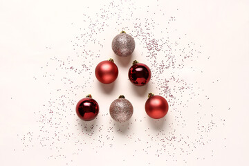 Composition with Christmas balls and confetti on light background