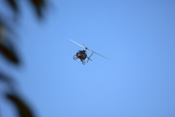 A helicopter crosses the blue sky with clouds. Transportation. Urban.