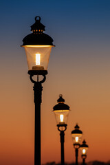 Vintage street lamps at sunset. - 664645415