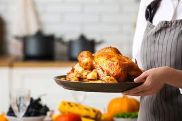 Woman with tasty turkey for Thanksgiving Day in kitchen, closeup