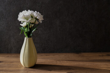 グレーの壁背景の花瓶に活けた白菊
