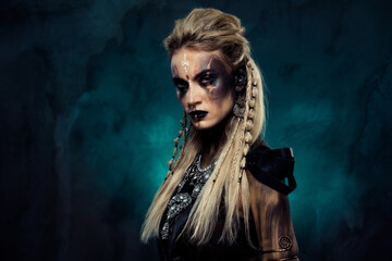 Photo of dangerous powerful shield maiden tribal queen demonic viking ready for fierce war over dark mist background - obrazy, fototapety, plakaty