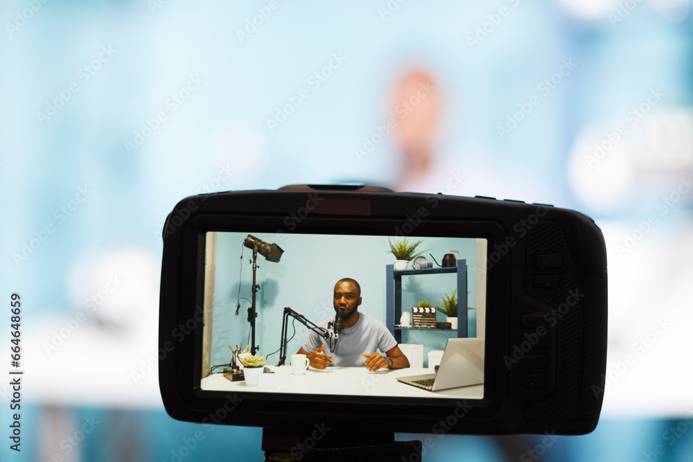 Poster blogger streaming while creating digital content and recording video with professional camera closeu