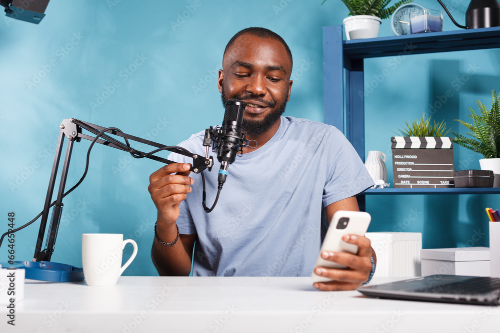 Poster cheerful blogger sharing insights and news from smartphone while streaming online. smiling african a