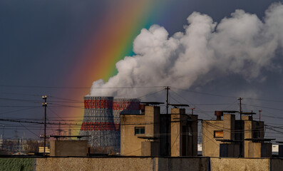 Heat and power plant with smoke pipes and rainbow with snow storm on a cloudy autumn day. Thermal power industry. Place for your text.