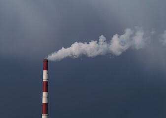 Heat and power plant with smoke pipes in snow storm on a cloudy autumn day. Thermal power industry. Place for your text.