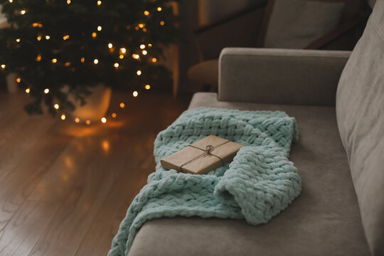 Christmas gift wrapped in craft paper under a tree. New Year card