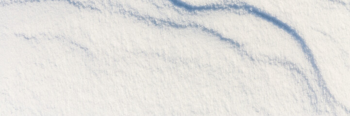 Beautiful winter background with snowy ground. Natural snow texture. Wind sculpted patterns on snow...