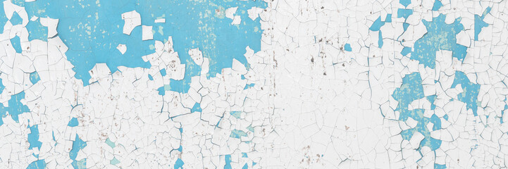 Peeling paint on the wall. Old concrete wall with cracked flaking paint. Weathered rough painted surface with patterns of cracks and peeling. High resolution texture for background and design. Closeup